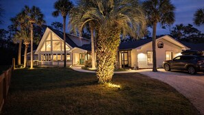 A two-story house with a large front porch, a garage, and a driveway. - Heated Pool • Sauna • Hot Tub • Game Room • Beach • Golf Cart • Sleeps 15 (Port St. Joe)