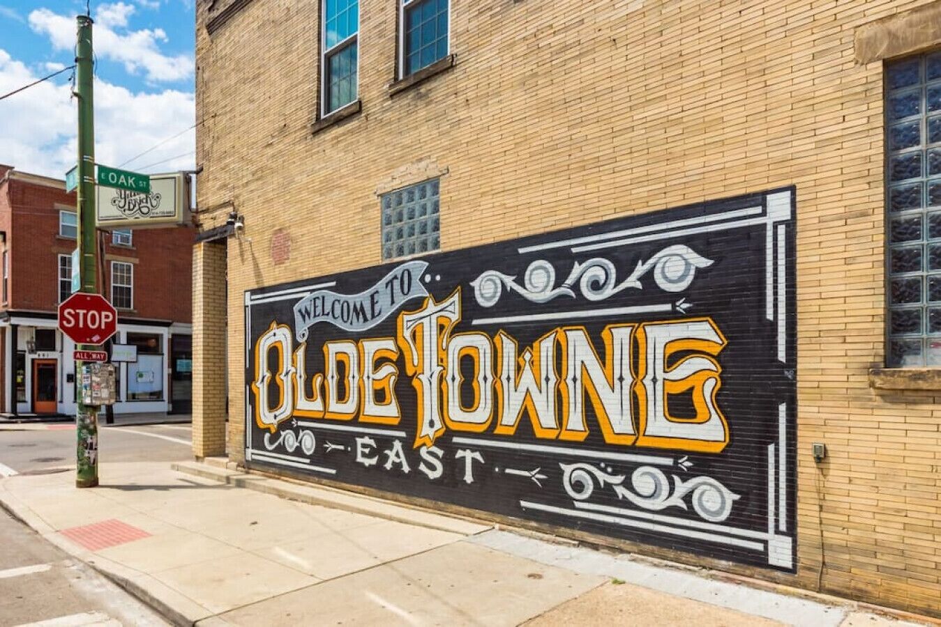 Een straatbordje met 'Welcome to Olde Towne East' op een gebouw geschilderd.