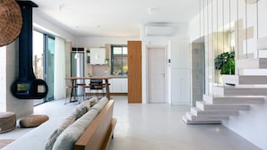A modern kitchen with a dining area, a staircase, and a living room with a sofa and cushions. - NEW Lux Villa*Heated SaltyPool*BBQ*SeaView*Garden (Chania)
