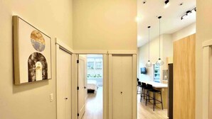 Een modern interieur met een gang die leidt naar een eetgedeelte en een slaapkamer.