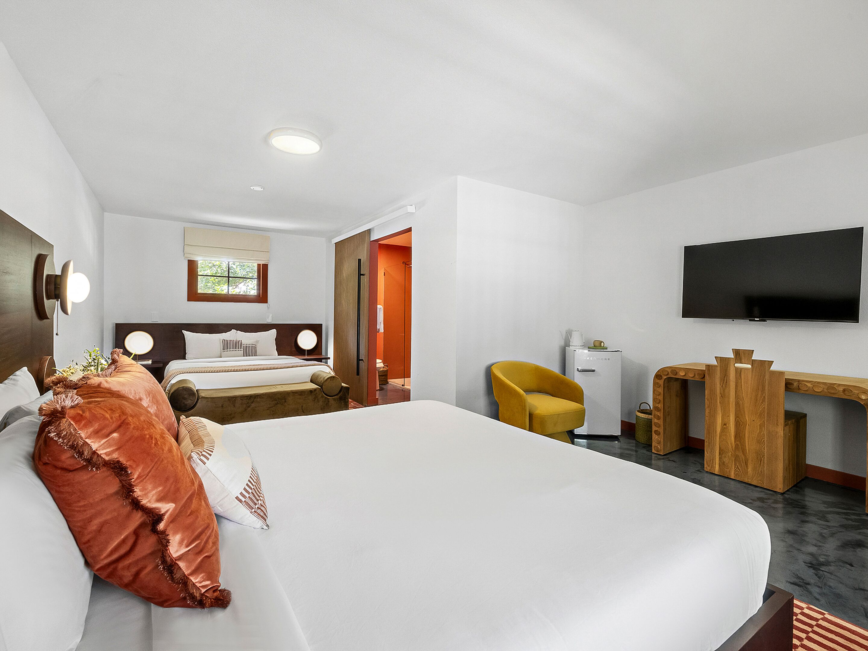 Une chambre d’hôtel avec un grand lit, un bureau, une télévision et une fenêtre.