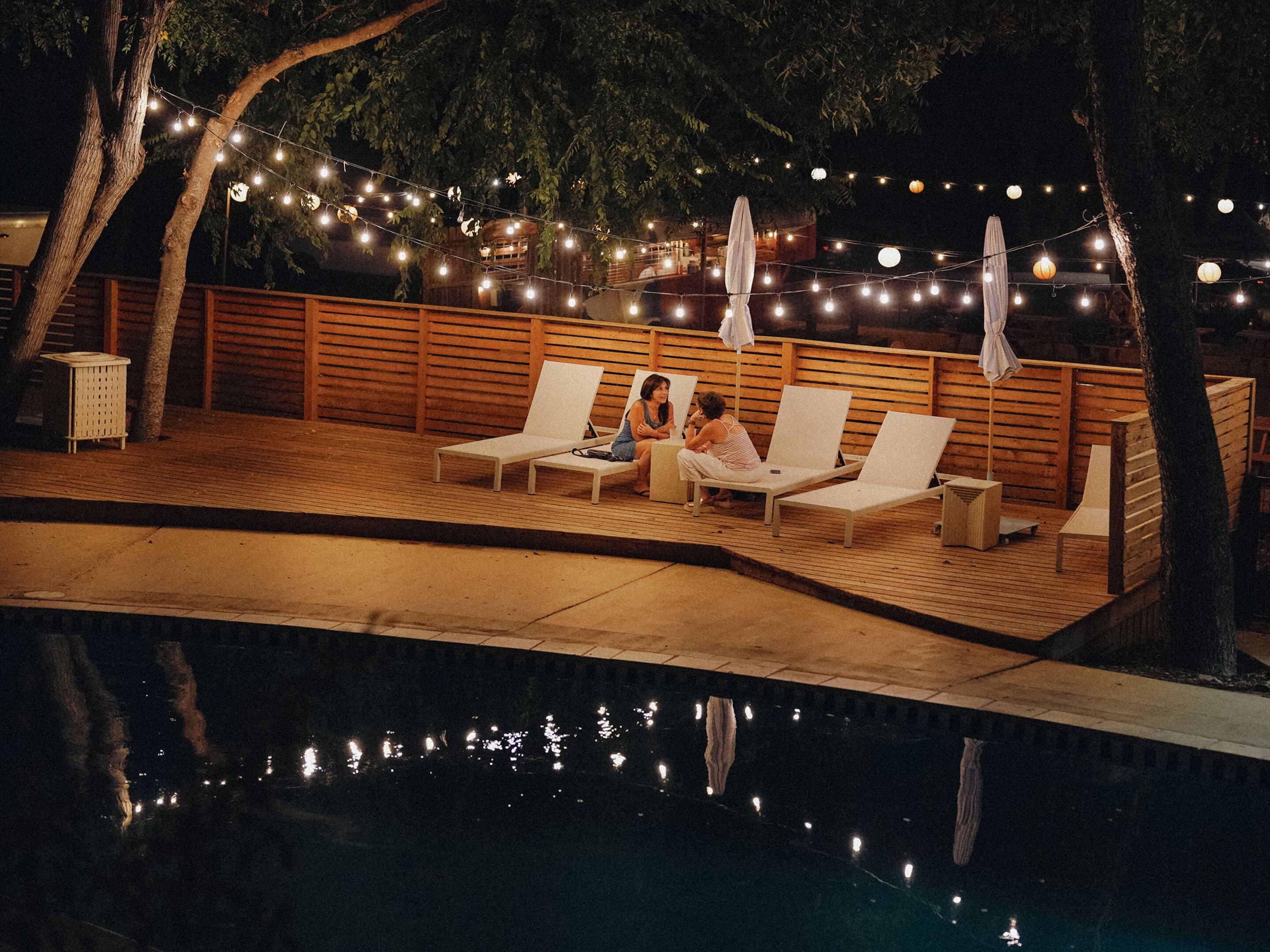 Een buitenzwembad, parasols bij het zwembad en ligstoelen