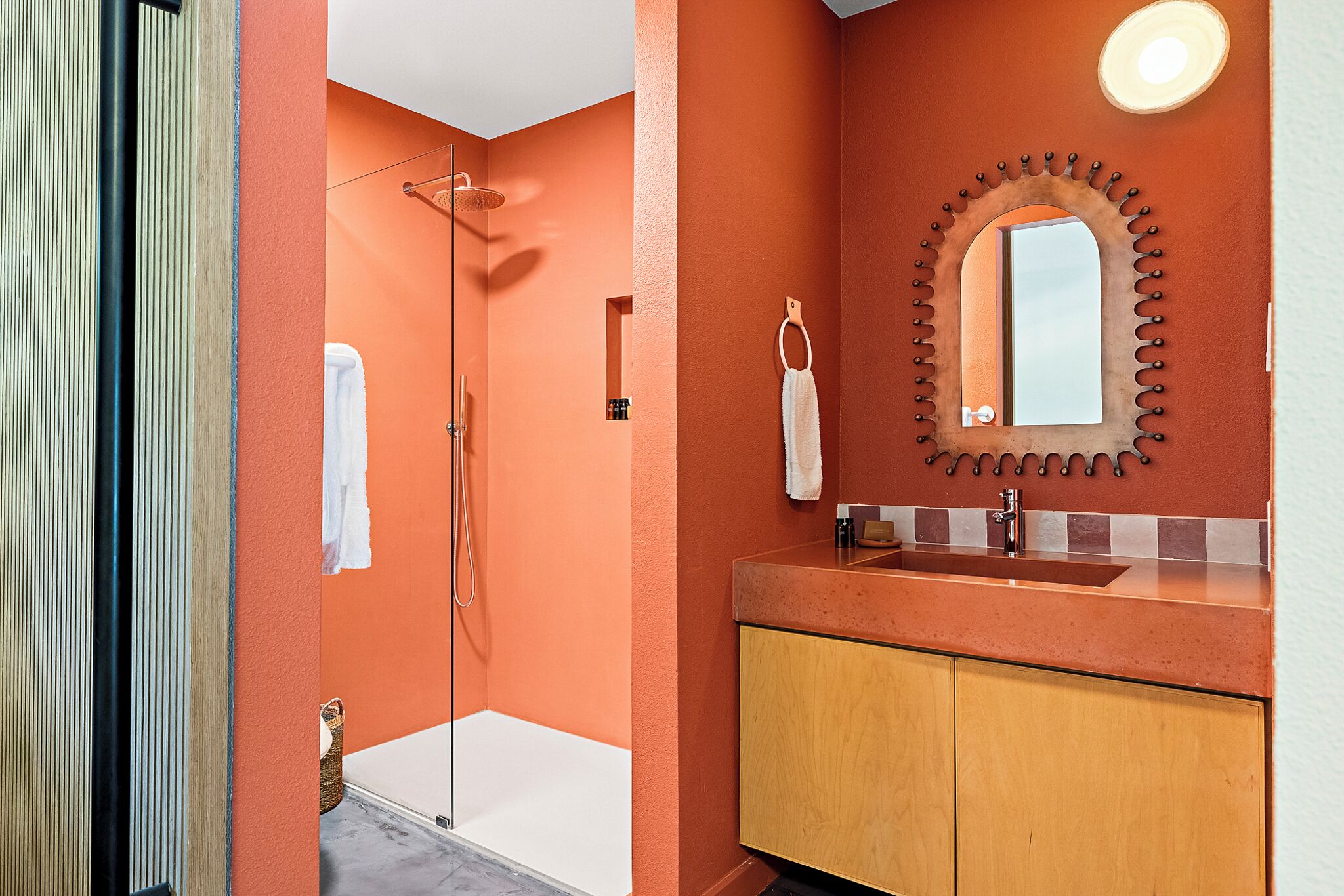 A bathroom with a shower, a sink, and a mirror.