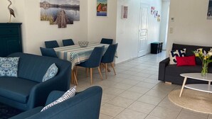 Un salon moderne avec un coin repas, comprenant un canapé, une table basse et une table à manger avec des chaises.