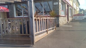 A building with a stone facade, a wooden fence, and a sign indicating it is a bar, hotel, and restaurant. - La renaissance (Condé-en-Normandie)