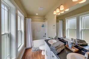 A bathroom with a bathtub, two sinks, a large mirror, and a shower curtain. - 'Marie's Place' - Walk to Subiaco Abbey! (Subiaco)