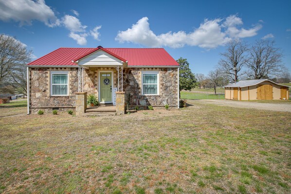 A stone house with a red roof, a front porch, and a small front yard. - 'Marie's Place' - Walk to Subiaco Abbey! (Subiaco)
