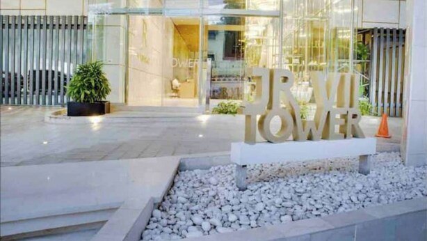 Une entrée moderne d’un immeuble, avec une enseigne indiquant « DOWNTOWER ».