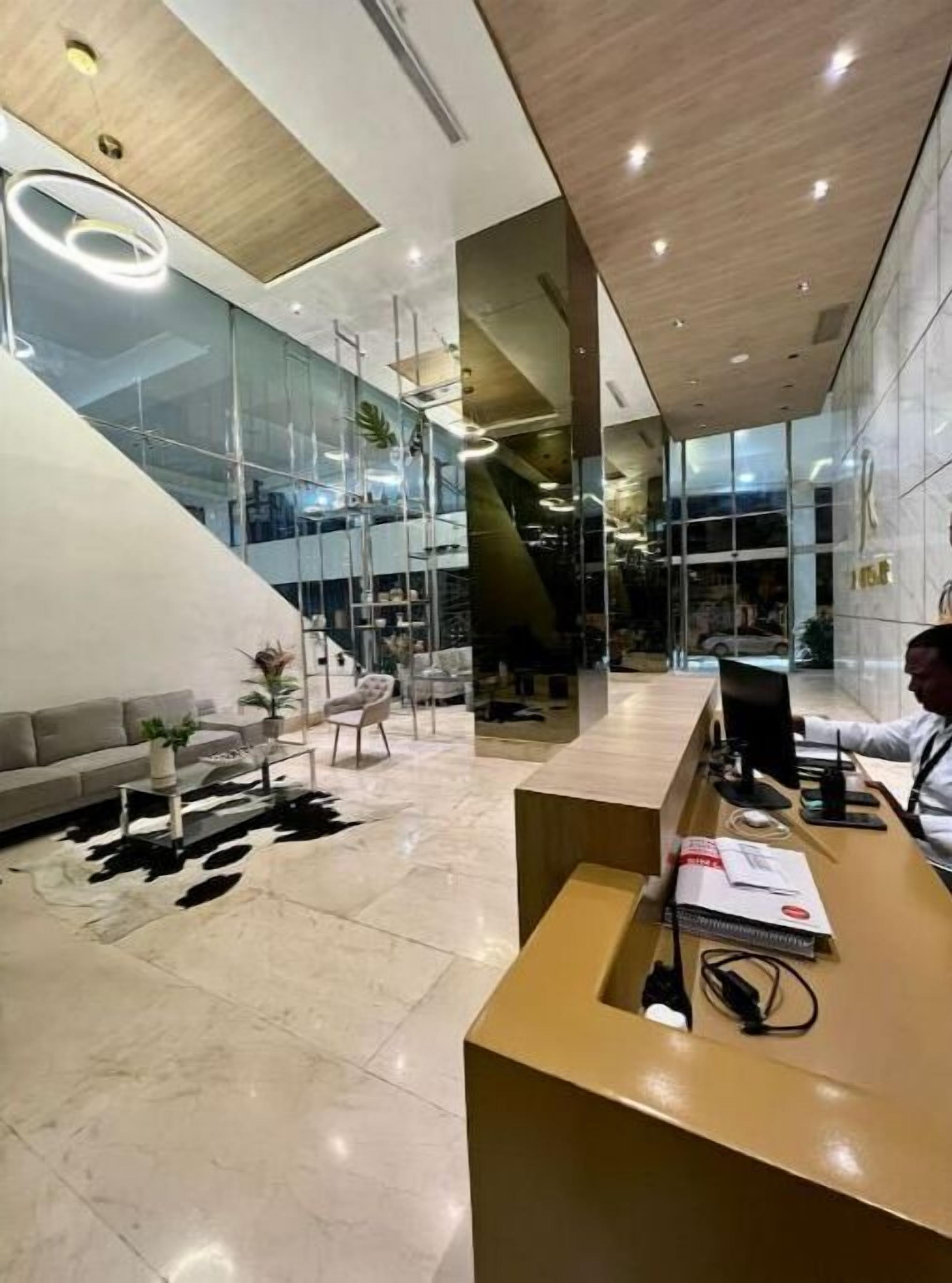 A modern reception area with a wooden reception desk, a sofa, and a coffee table.