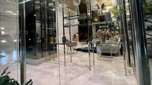 Un intérieur moderne avec des cloisons en verre, un espace salon et une cuisine ouverte.
