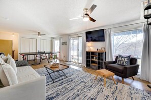 Relax in this stylish living room with a large sofa, coffee table, and dining area.