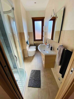 Een douche, een haardroger, een bidet, handdoeken