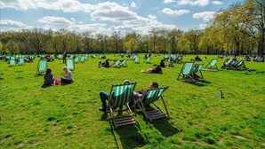 A park with numerous green and white striped lawn chairs and tables spread across a grassy field. - Immaculate 2-bed House in London, Mayfair (London)