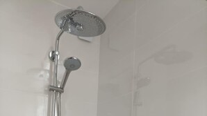 Een douche met een handdouche en een douchekoof.