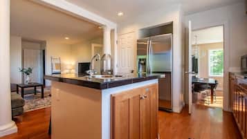 A modern kitchen with a central island, stainless steel appliances, and a dining area with a table and chairs.