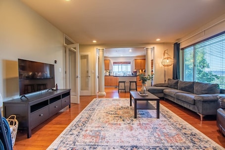 A living room with a TV, sofa, coffee table, and a rug.. Spacious Family Retreat Near Seattle Stadiums