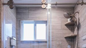 A shower area with a glass door, a window, and a toilet. - Peachtree/Royal Oak`s Sweet Spot/King Bed (Royal Oak)