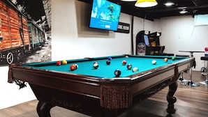 A pool table with balls, a television screen, and a sign that reads "AMIC ROOM". - Peachtree/Royal Oak`s Sweet Spot/King Bed (Royal Oak)