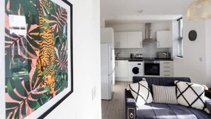 Een moderne keuken met witte kastjes, een ingebouwde oven en een magnetron.