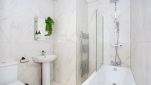 A modern bathroom with a white sink, mirror, and shower. - Trendy 2 Bed Flat, close to Beach & Restaurants (Southend-on-Sea)