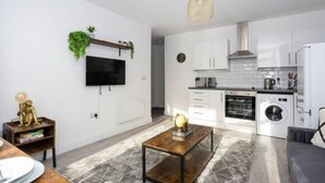 A modern apartment with a living room, dining area, kitchen, and laundry area. - Trendy 2 Bed Flat, close to Beach & Restaurants (Southend-on-Sea)