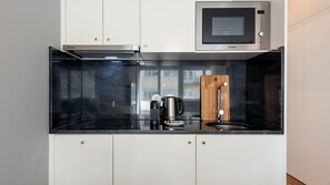 Prepare simple meals with ease on this sleek countertop, complete with essential appliances for your convenience.
#Kitchenette #ModernKitchen #LovelyStay - Ceuta 70 - Apartment 2.4 by LovelyStay (Porto)