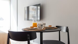 Ein Esstisch mit einem Glasbehälter Orangensaft, zwei Tassen und einem Teller mit Gebäck.