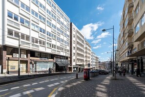 A street with modern buildings, a tram line, and a pedestrian walkway. - Ceuta 70 - Apartment 3.3 by LovelyStay (Porto)