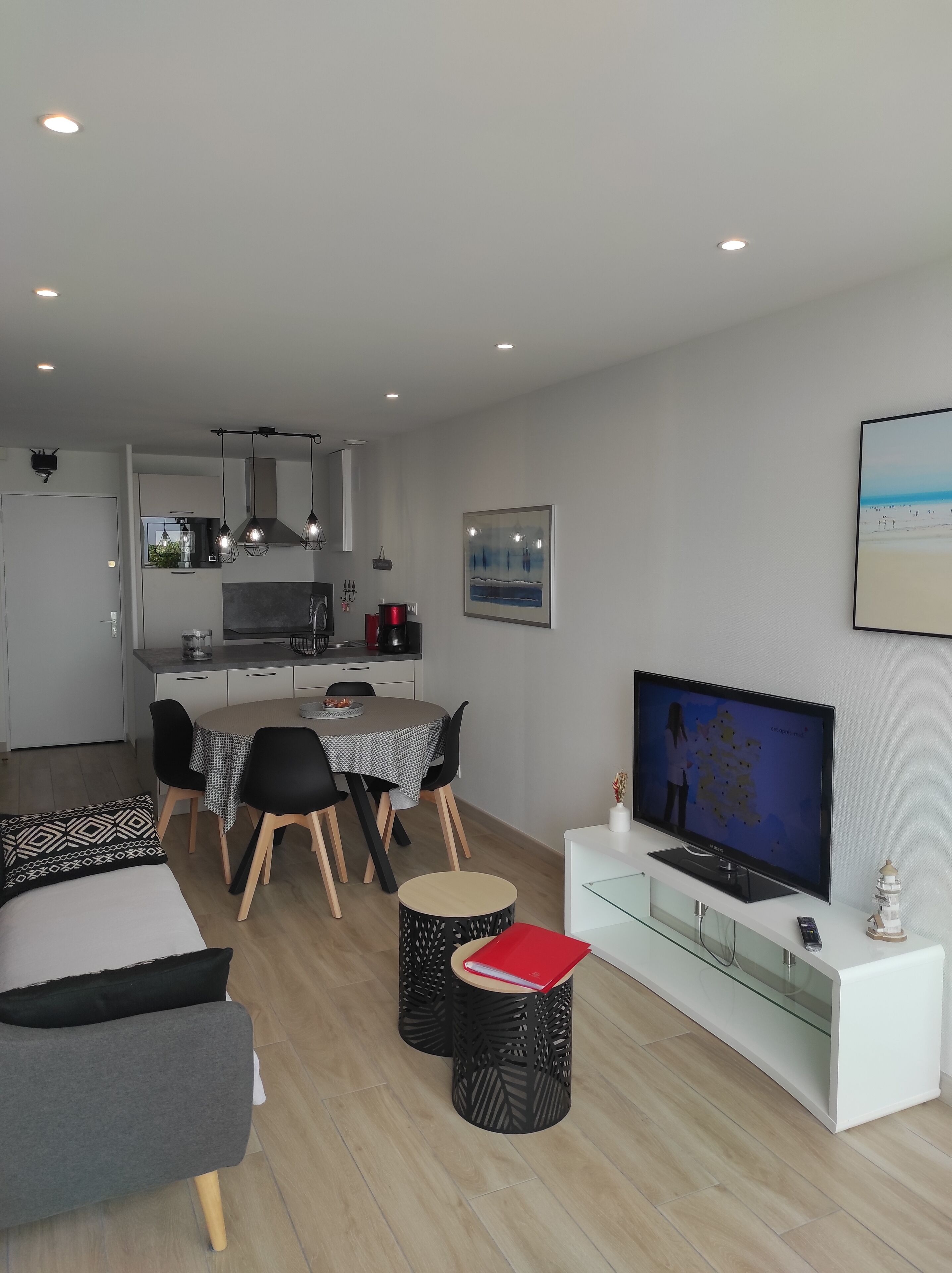 Un salon moderne comprenant un coin repas, une cuisine et un téléviseur.