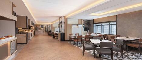 A modern dining area with a long counter, multiple tables, and chairs.