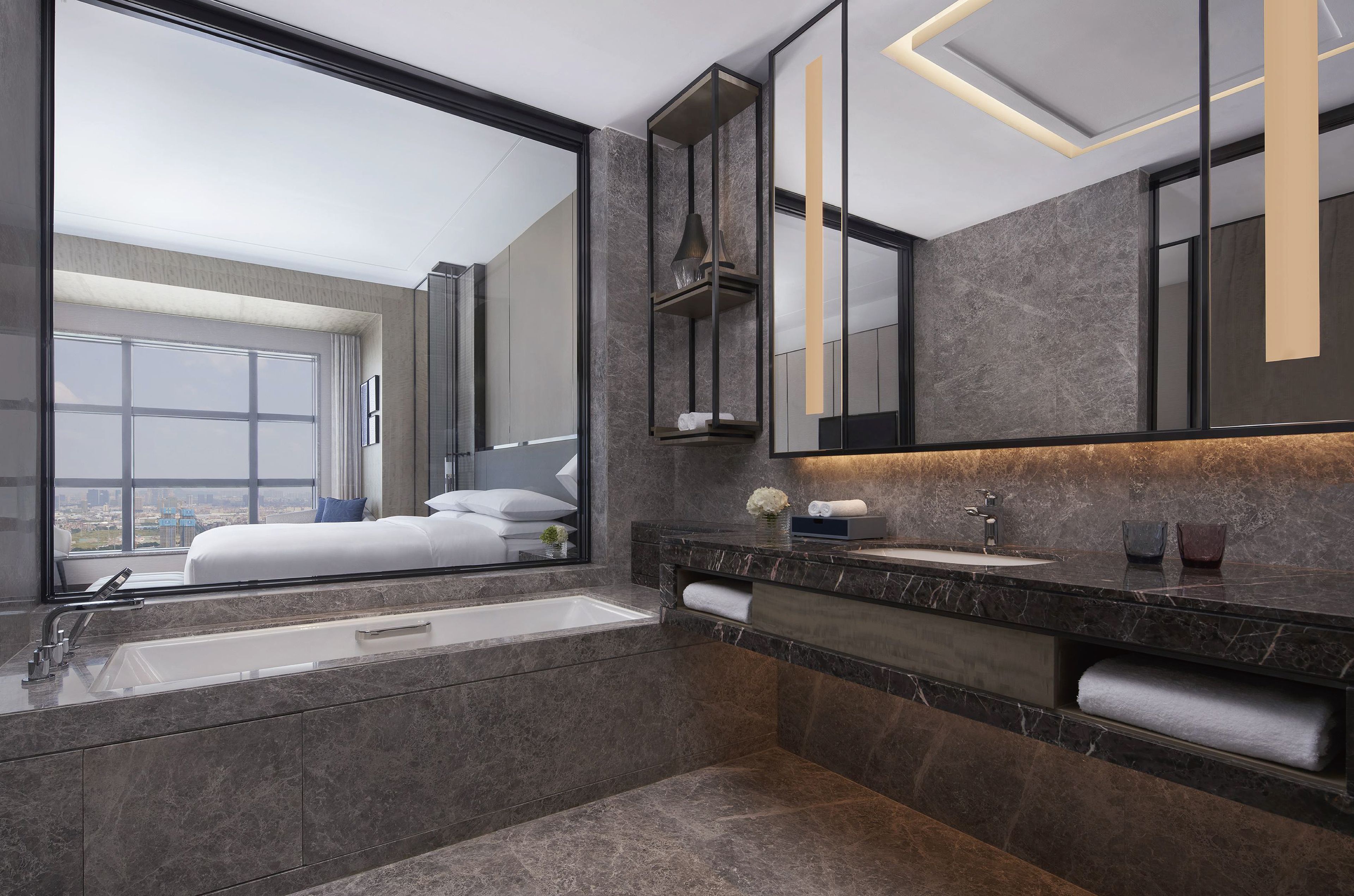 Une salle de bain moderne avec un grand miroir, une baignoire et un meuble-lavabo.