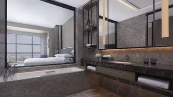 Une salle de bain moderne avec un grand miroir, une baignoire et un meuble-lavabo.