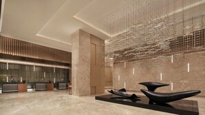A modern lobby with a reception desk, marble flooring, and contemporary art pieces. - Courtyard by Marriott Foshan (Foshan)