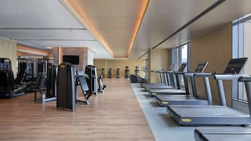 Ett gym med löpband, styrketräningsmaskiner och annan träningsutrustning.