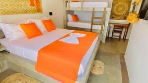 Um quarto com uma cama beliche, uma cama de solteiro com roupa de cama laranja, um tapete tecido, uma escada de madeira, uma obra de arte na parede e um candeeiro suspenso.