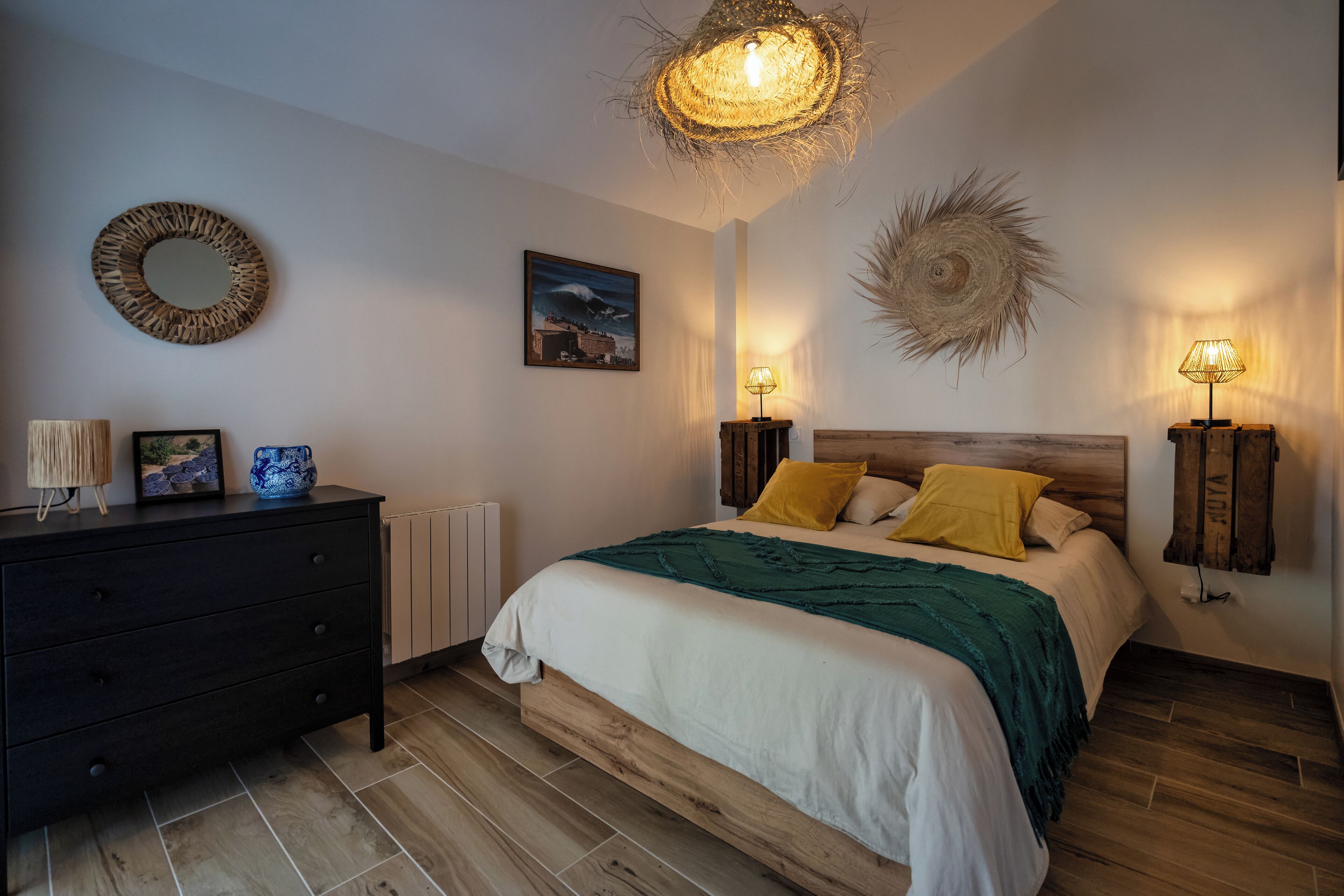 Ein Schlafzimmer mit Bett, Nachttischen, Kommode und Wanddekoration.