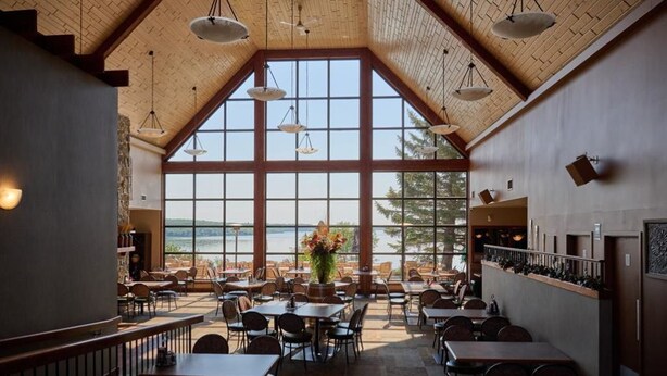A spacious dining area with high ceilings and large windows overlooking a scenic view.