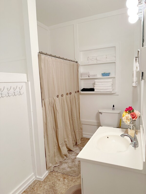 A bathroom with a white sink, a toilet, and a shower curtain.