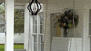 A white porch with a swing chair and a hanging light fixture. - House - Wetumpka (Wetumpka)
