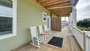 A covered porch with wooden flooring, white rocking chairs, and a black doormat. - Emerald Isle Getaway w/ Decks & Beach Views! (Emerald Isle)