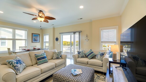 A spacious living room with two sofas, a coffee table, and a ceiling fan. - Emerald Isle Getaway w/ Decks & Beach Views! (Emerald Isle)