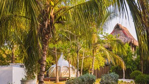 A thatched-roof structure with a white tent in a tropical garden setting. - Marine Beach Club & Hotel By Tequendama (Cartagena)