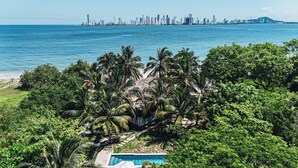 A tropical resort with a pool, palm trees, and a city skyline view. - Marine Beach Club & Hotel By Tequendama (Cartagena)