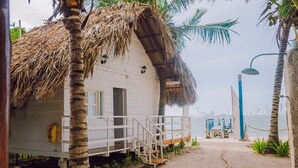 A beachside building with a thatched roof, a wooden deck, and a view of the sea. - Marine Beach Club & Hotel By Tequendama (Cartagena)