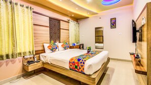 A modern hotel room with a large bed, bedside tables, a TV, and a wooden headboard. - FabHotel Emara Boutique - Near Koramangala (Bengaluru)