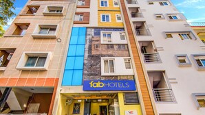 A multi-story hotel with a prominent 'fabHOTELS' sign, balconies, and a mix of window styles. - FabHotel Emara Boutique - Near Koramangala (Bengaluru)