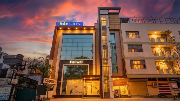 Un moderno edificio de hotel con un cartel que dice 'fabHOTELS' y 'Paliwal' en la fachada.