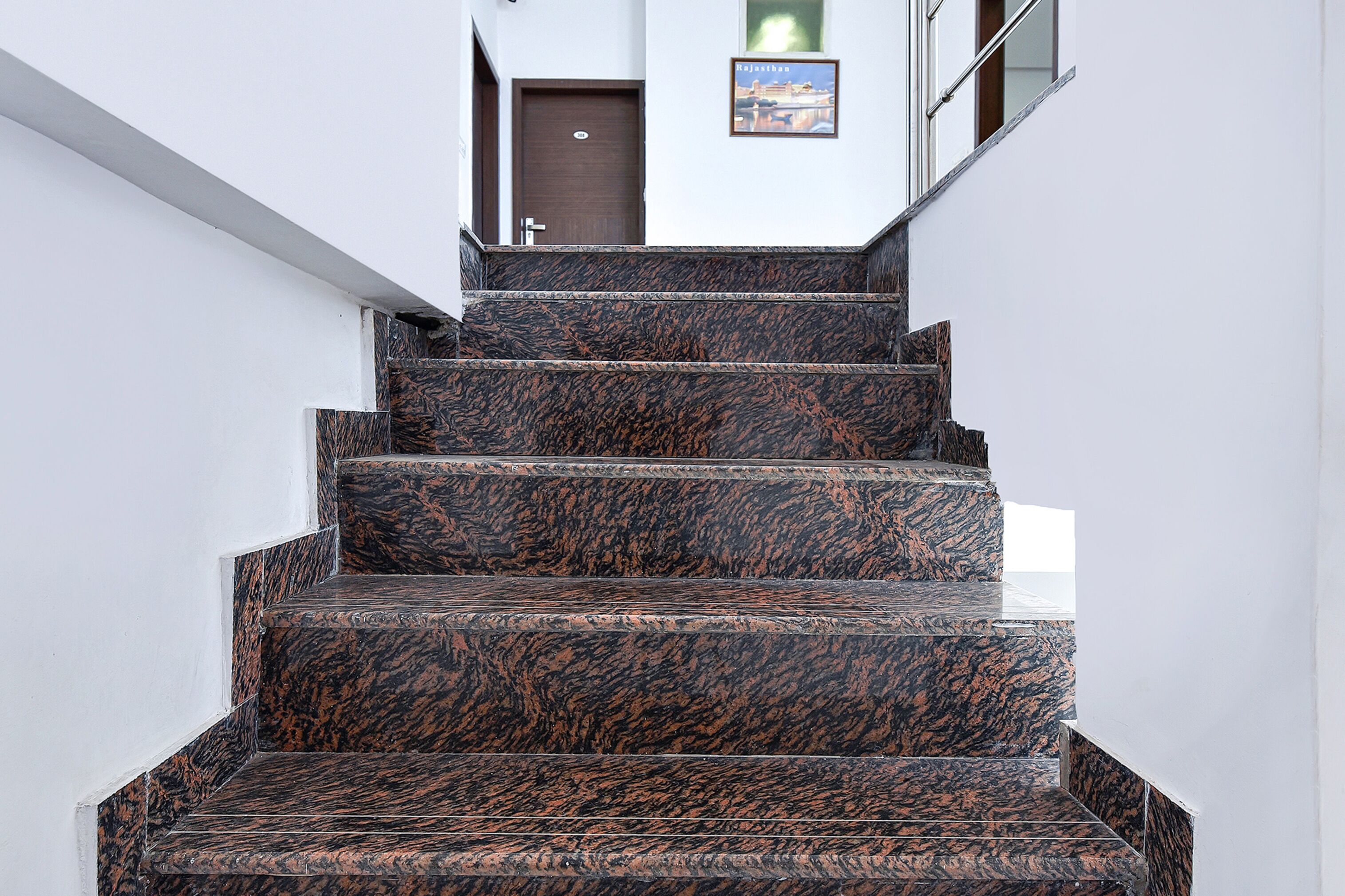 A staircase with dark patterned steps leading to a door.