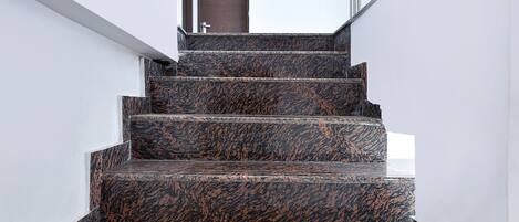 A staircase with dark patterned steps leading to a door.