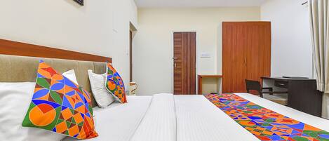 A hotel room with a bed, a desk, and a chair.